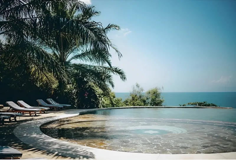 The two-level infinity pool with its integrated Jacuzzi, loungers and palms above Lake Tanganyika