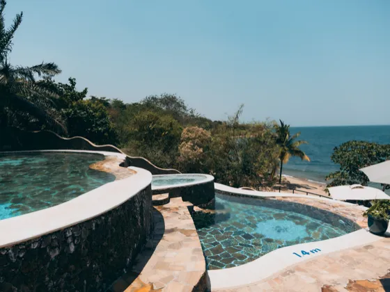 The pools stepping down through the gardens towards the beach and the lake