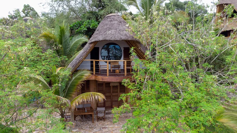 Une villa sous chaume à deux niveaux, avec fenêtre ronde et balcon en bois, vue du ciel