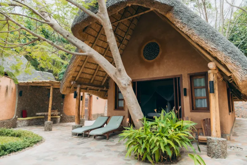 Le bungalow Citrine, rond et sous chaume, parmi les bananiers et les manguiers, un fauteuil en bois sur sa terrasse incurvée